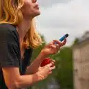 a woman holding a cup and a cell phone