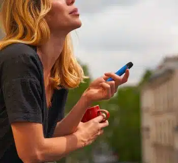 a woman holding a cup and a cell phone