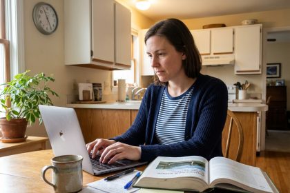 Femme concentrée travaillant à la maison avec ordinateur et notes