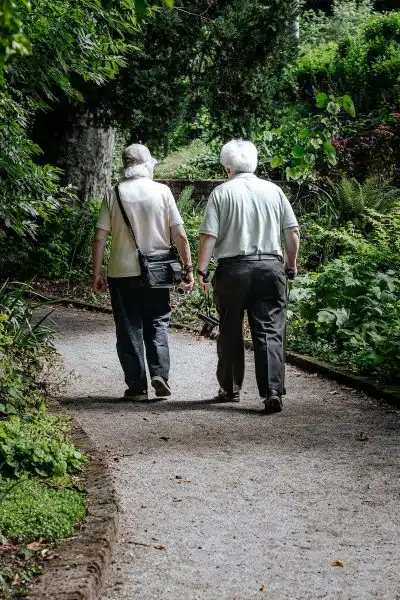 man in white shirt and blue denim jeans walking on pathway