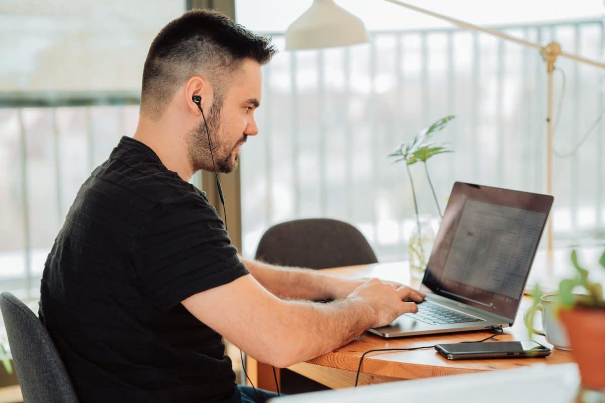 man in black t-shirt using laptop computer