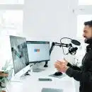 man in black jacket holding black corded computer mouse