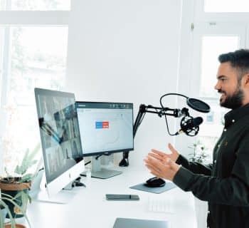 man in black jacket holding black corded computer mouse